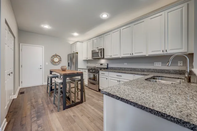 a kitchen with stainless steel appliances granite countertop a stove top oven a sink a counter space and cabinets