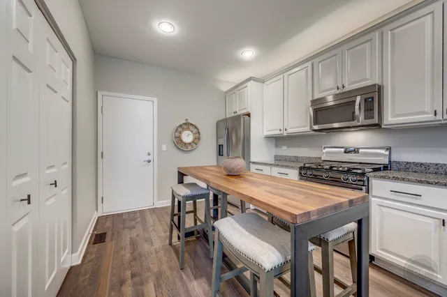 a kitchen with stainless steel appliances a stove a sink island and a refrigerator