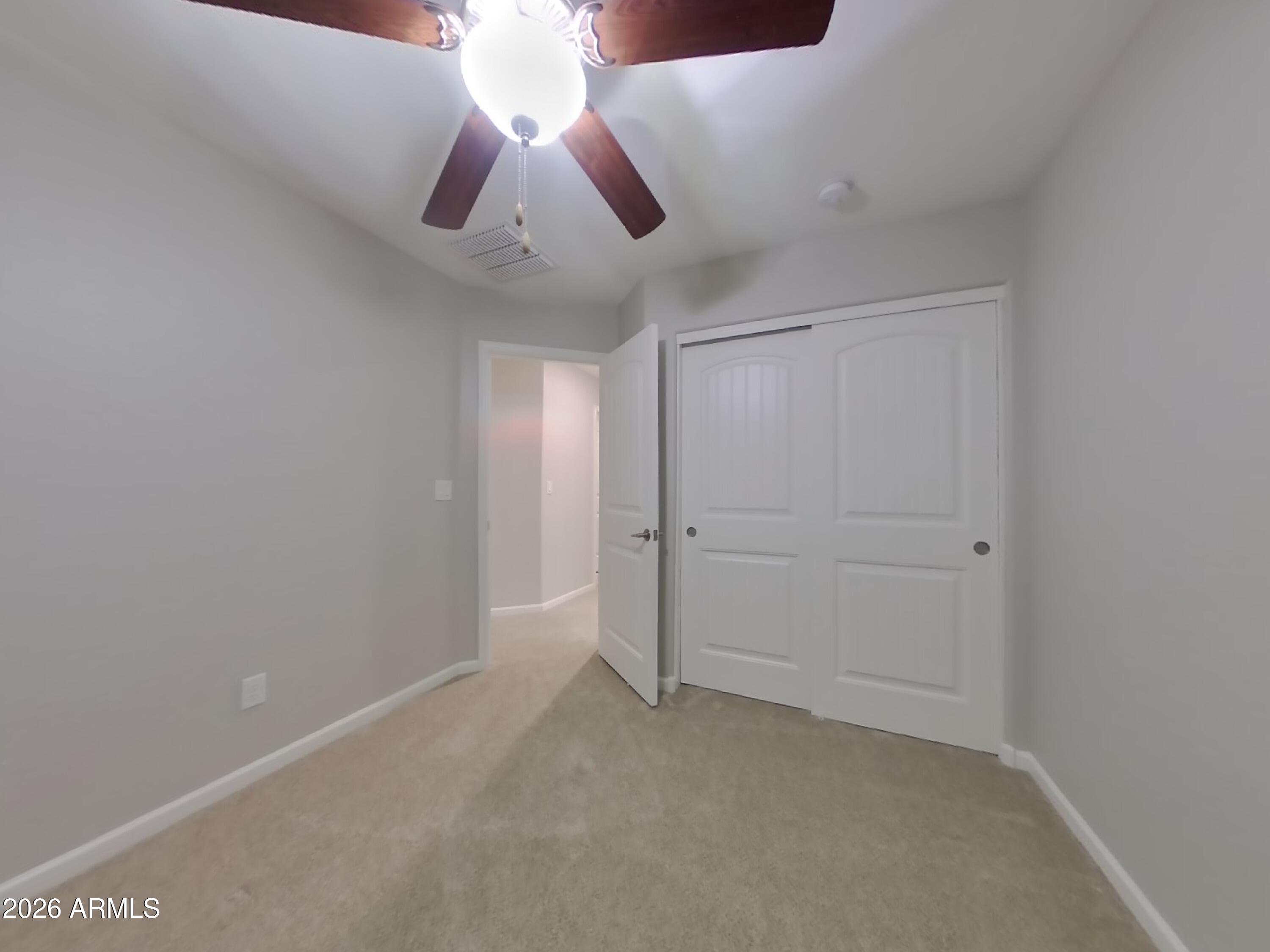 12563 West Gentle Rain Road Peoria, AZ 85383 - Photo 11 of 16 an empty room with a ceiling fan and window