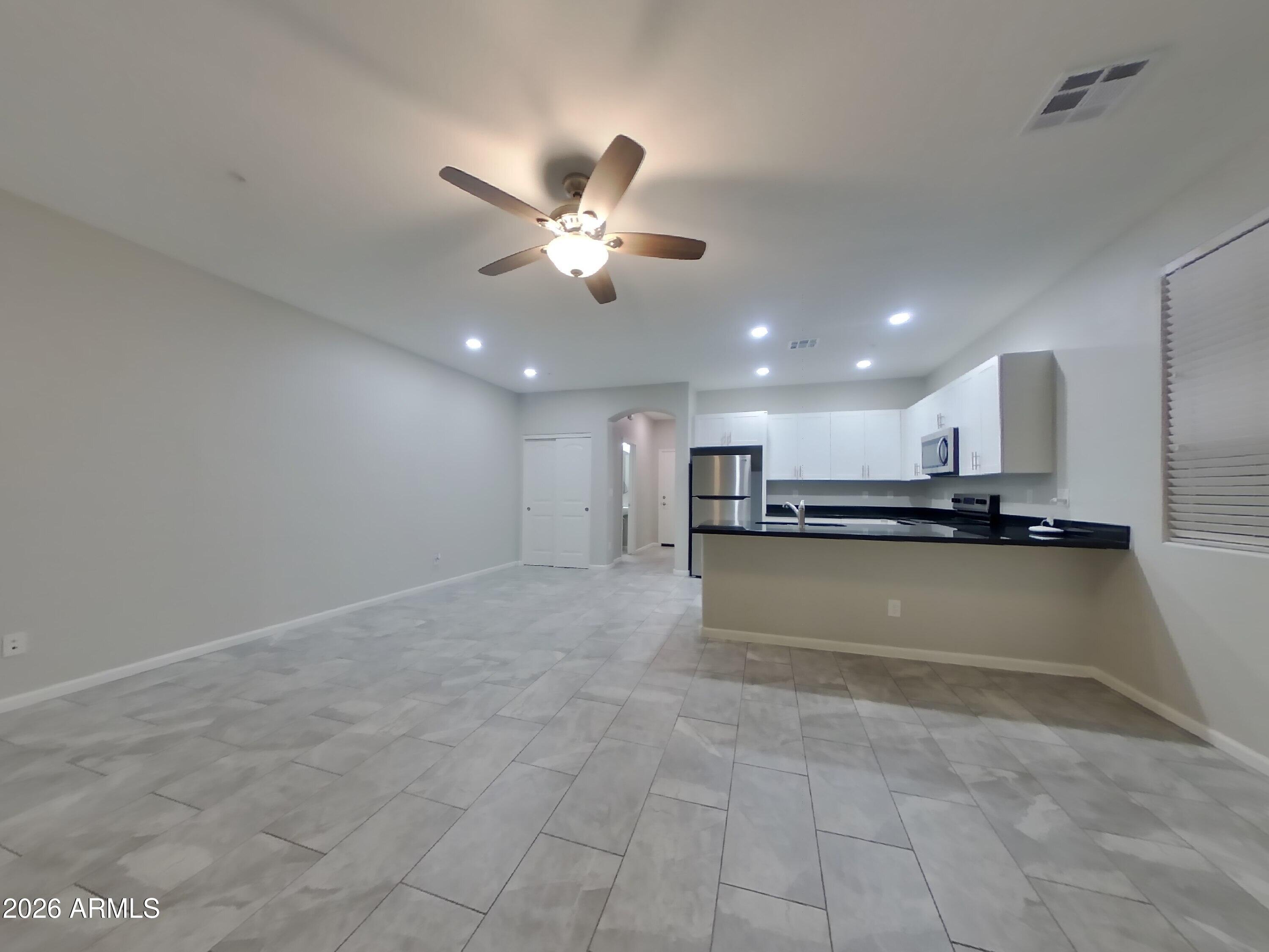 12563 West Gentle Rain Road Peoria, AZ 85383 - Photo 3 of 16 a view of kitchen with kitchen island a sink appliances and a cabinets
