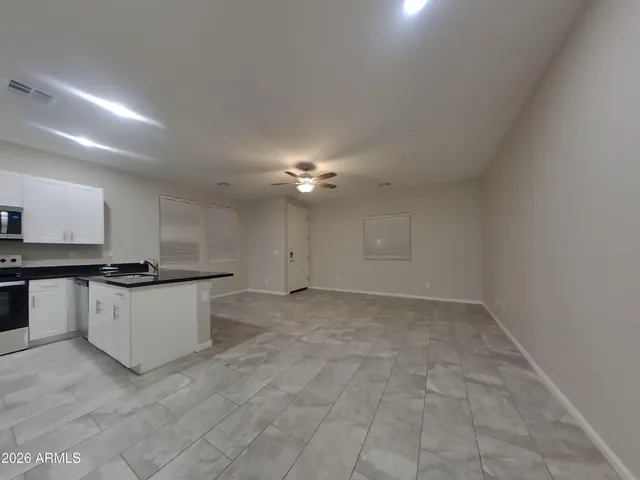 a view of a kitchen with a sink and dishwasher a stove top oven with wooden floor