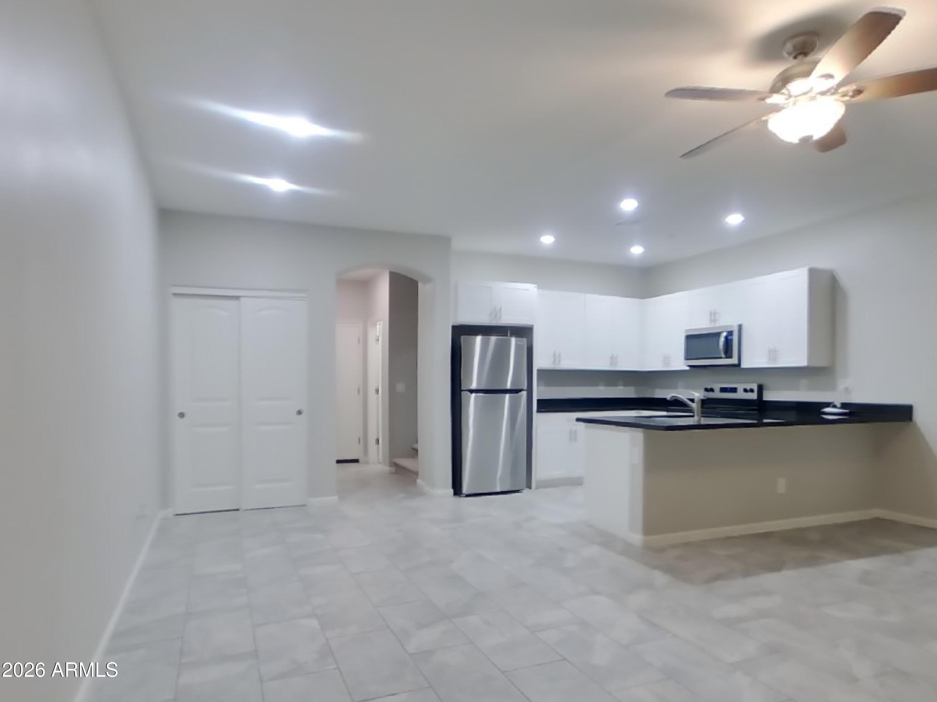 12563 West Gentle Rain Road Peoria, AZ 85383 - Photo 5 of 16 a kitchen with stainless steel appliances a refrigerator and a stove top oven