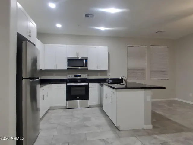 a kitchen with stainless steel appliances a sink stove and refrigerator
