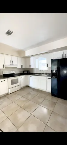 a view of a kitchen with granite countertop lots of white cabinets