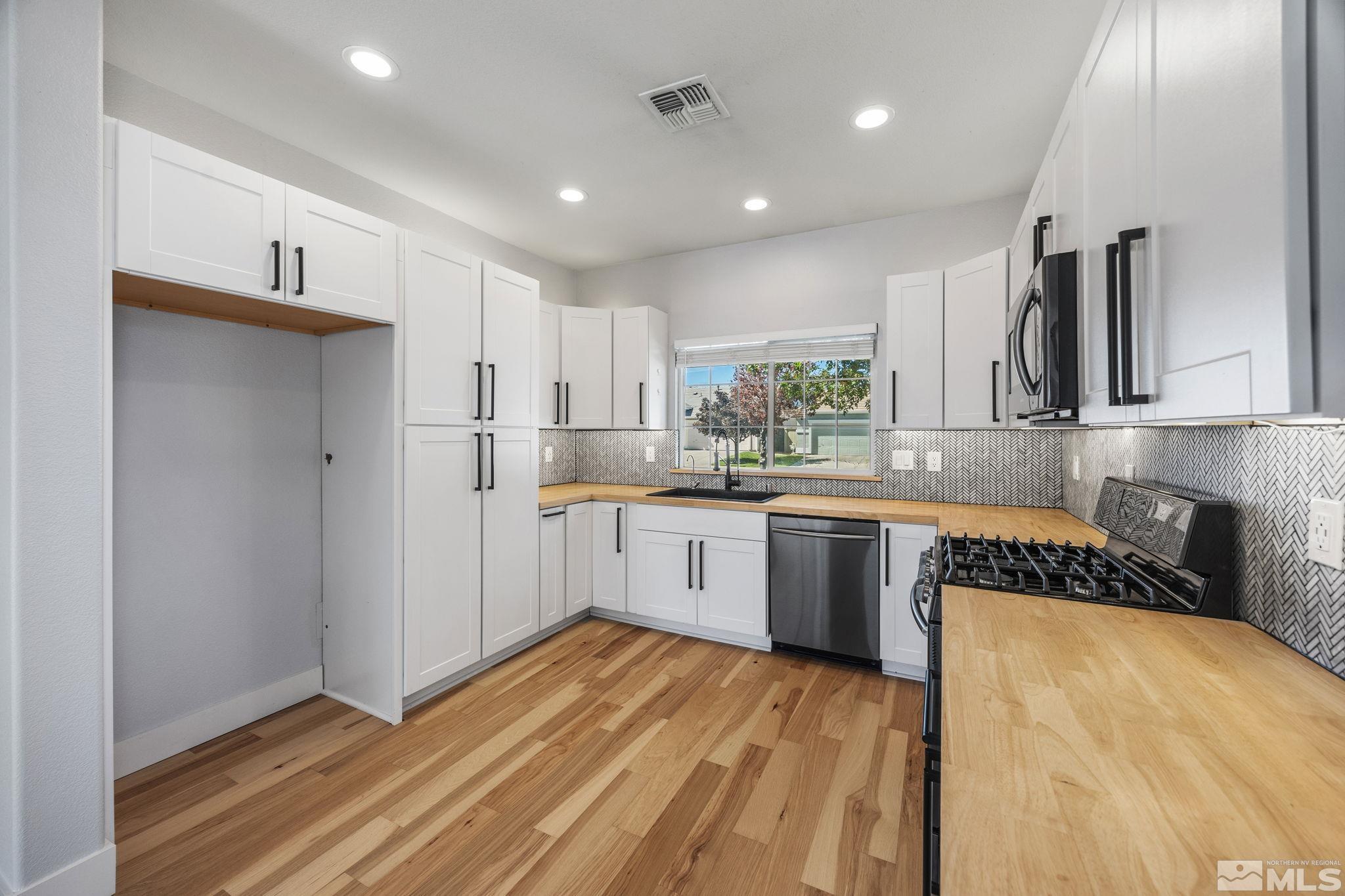 10600 Arbor Way Reno, NV 89521 - Photo 12 of 33 a kitchen with stainless steel appliances granite countertop a refrigerator sink and white cabinets