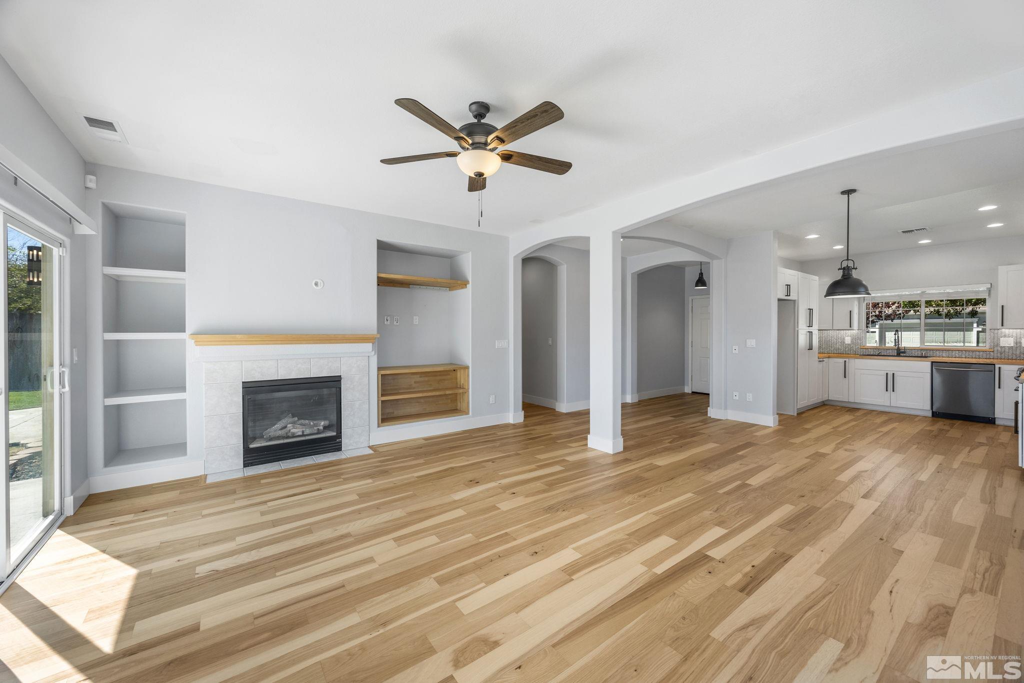 10600 Arbor Way Reno, NV 89521 - Photo 7 of 33 a view of a livingroom with a fireplace a ceiling fan and windows