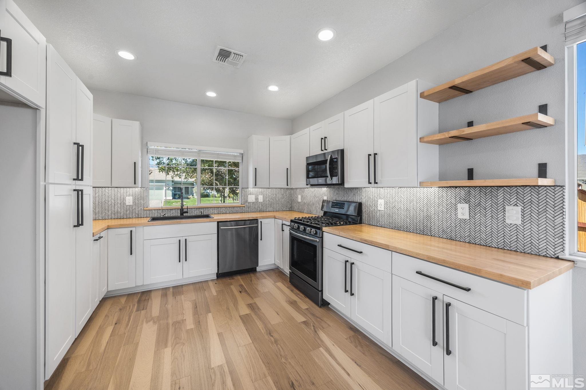 10600 Arbor Way Reno, NV 89521 - Photo 9 of 33 a kitchen with white cabinets sink and stainless steel appliances