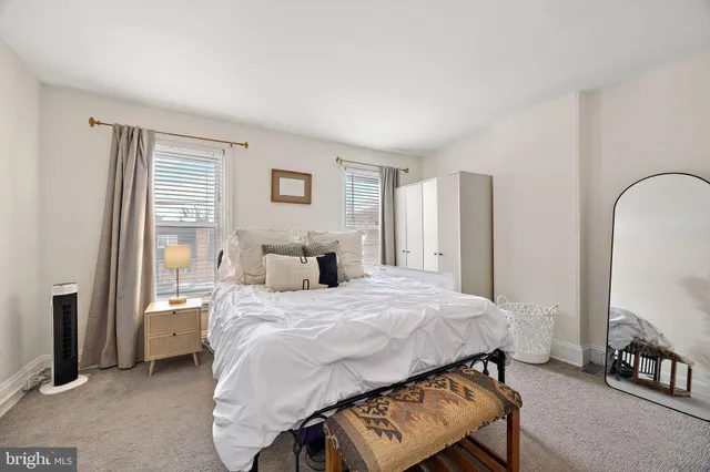 a bedroom with a bed a mirror and a window