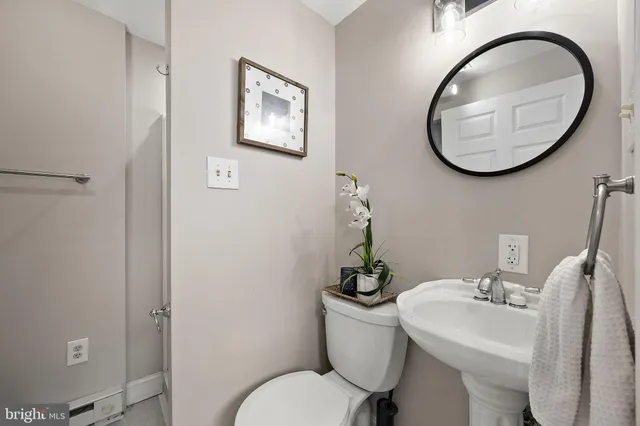 a bathroom with a toilet a sink and a mirror