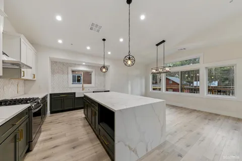 a kitchen with stainless steel appliances granite countertop wooden cabinets a stove top oven a sink and dishwasher