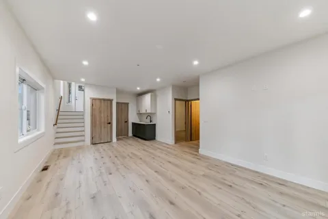 a view of a hallway with wooden floor