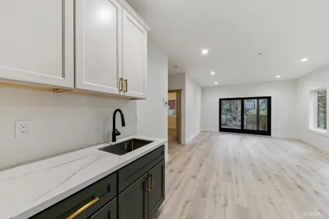a kitchen with granite countertop a sink stainless steel appliances and cabinets