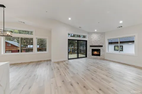 an empty room with wooden floor and fireplace