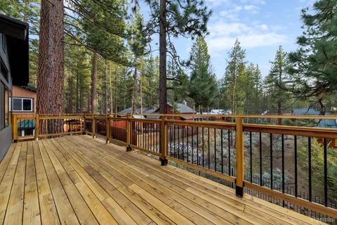 a view of a balcony with wooden floor and fence