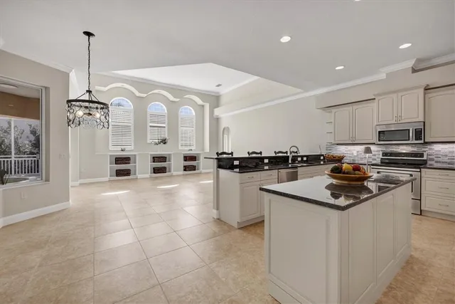 a kitchen with stainless steel appliances granite countertop a sink a stove and a refrigerator