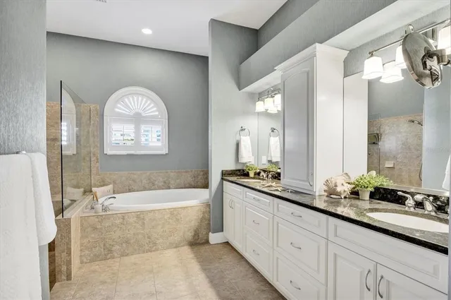 a spacious bathroom with a tub sink and mirror