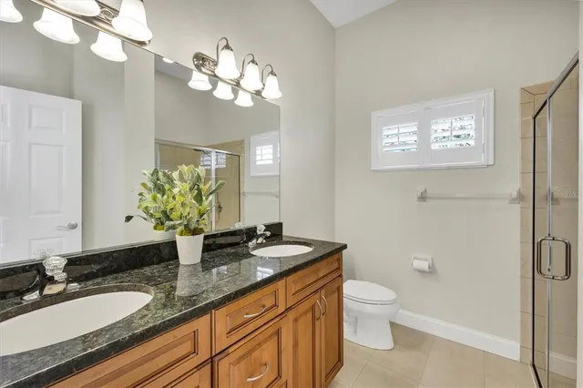 a bathroom with a granite countertop sink a toilet and a mirror