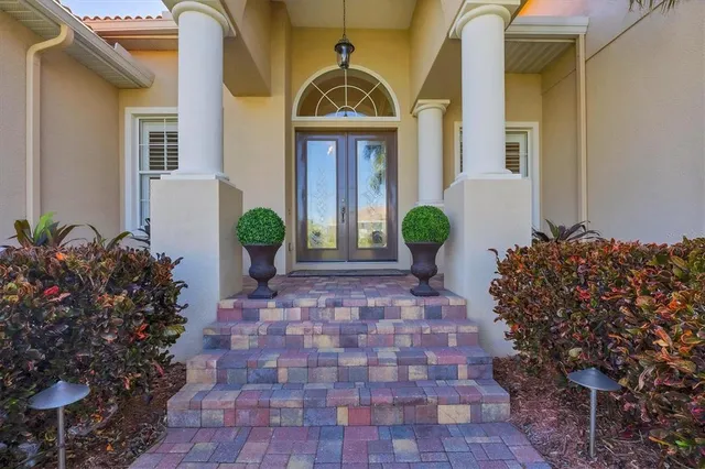 a view of a house with potted plants and a bench