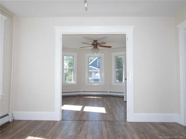 an empty room with wooden floor and windows