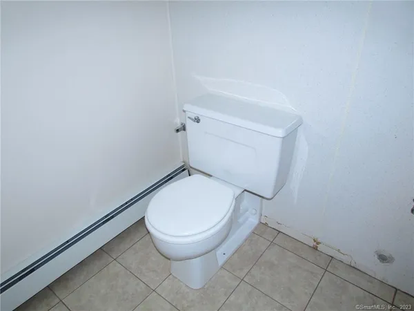 an empty room with wooden floor closet and fan