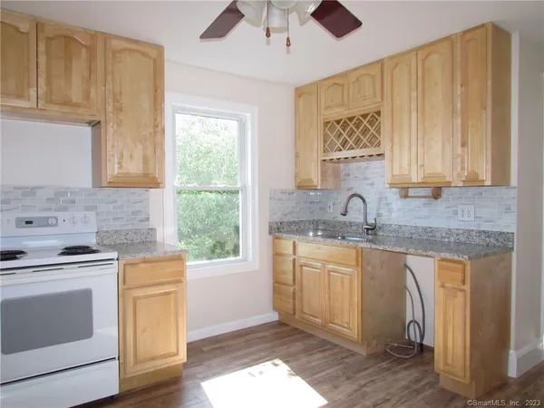 a kitchen with stainless steel appliances granite countertop a sink and cabinets with wooden floor