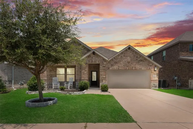 a front view of a house with a yard and trees