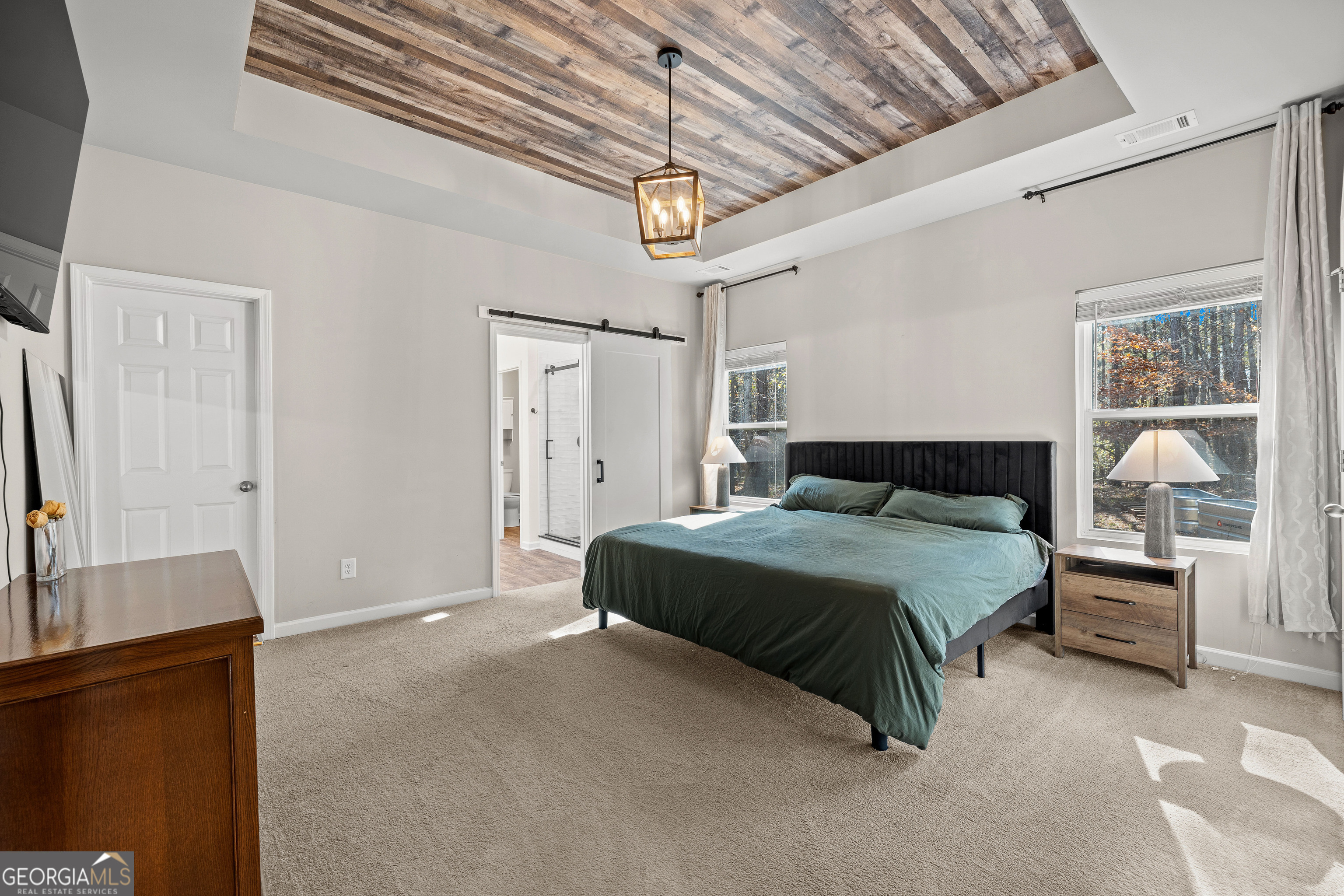 75 Homer Johnson Road Newnan, GA 30265 - Photo 21 of 51 a bedroom with a bed and a chandelier