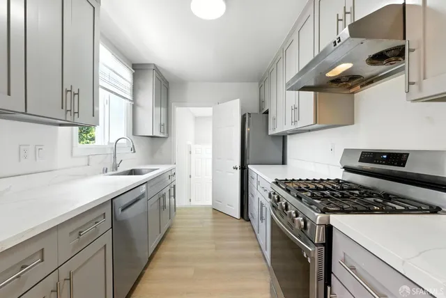 a kitchen with stainless steel appliances a sink stove and refrigerator