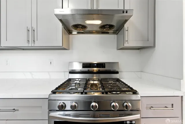 a stove top oven sitting inside of a kitchen