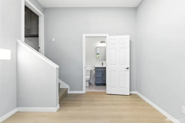 a view of a kitchen with a sink and an empty room