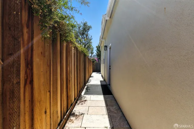 a view of a pathway of a house with wooden fence