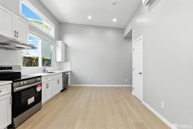 a kitchen with granite countertop a stove a sink and a refrigerator