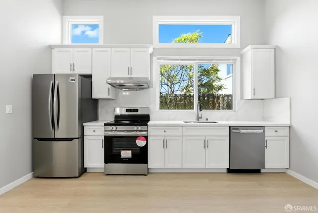a kitchen with stainless steel appliances a refrigerator sink and cabinets