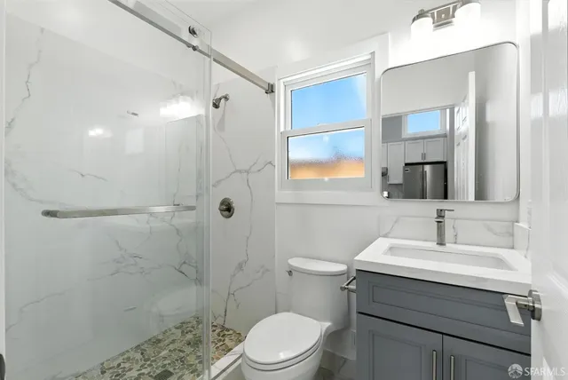 a bathroom with a sink a toilet and shower