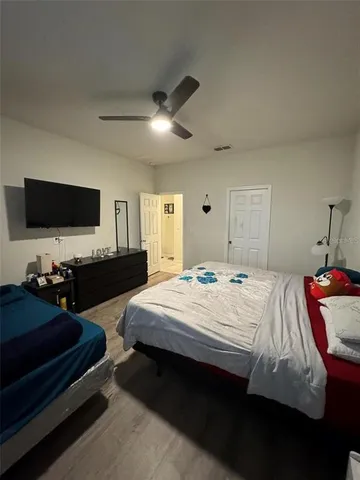 a bedroom with bed tv and window