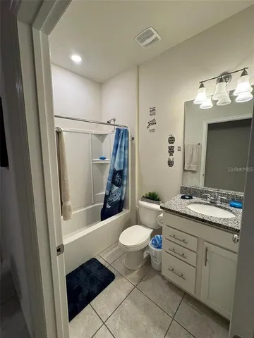 a bathroom with a double vanity sink toilet mirror and shower