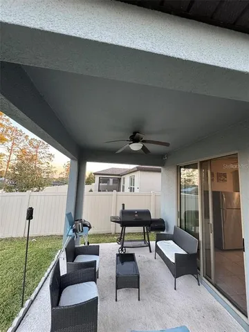 a living room with patio furniture and a large window