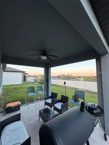 a living room with patio furniture and a garden