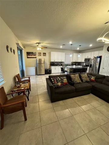 a large living room with stainless steel appliances kitchen island granite countertop a large window