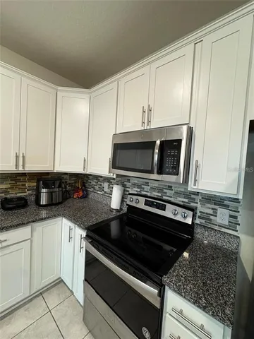 a kitchen with granite countertop a stove and a sink