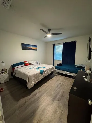 a bedroom with a bed and a dresser next to a window