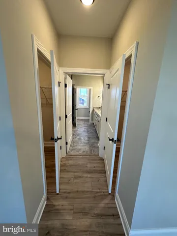 a view of a hallway with wooden floor and staircase