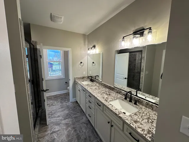 a bathroom with a double vanity sink and a mirror