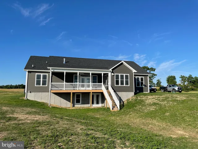 a house with green field in front of it