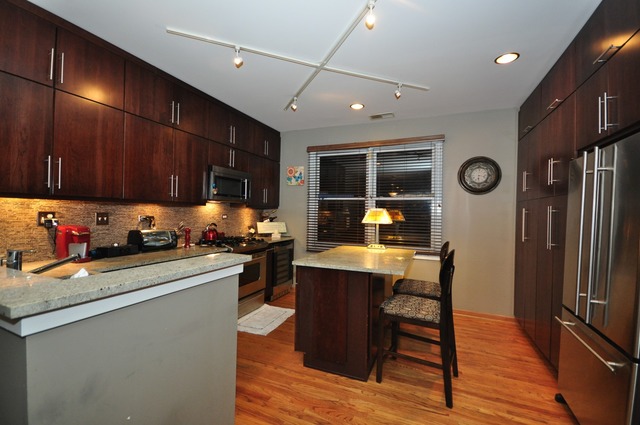 1812 South State Street, Unit 9 Chicago, IL 60616 - Photo 7 of 15 a kitchen with stainless steel appliances granite countertop a refrigerator stove microwave and sink