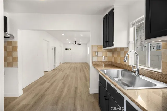 a kitchen with a sink stove top oven and refrigerator