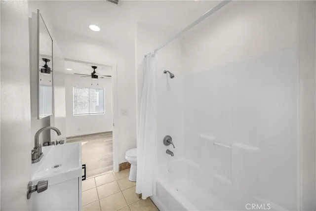 a view of a hallway with a chandelier fan and wooden floor