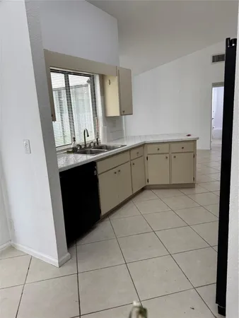 a room with a sink cabinets and window