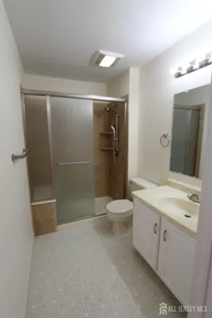 a bathroom with a sink a toilet and shower