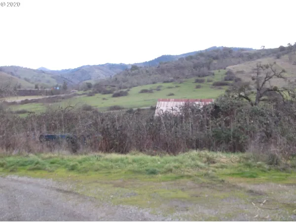 a view of a house with a yard and mountain view